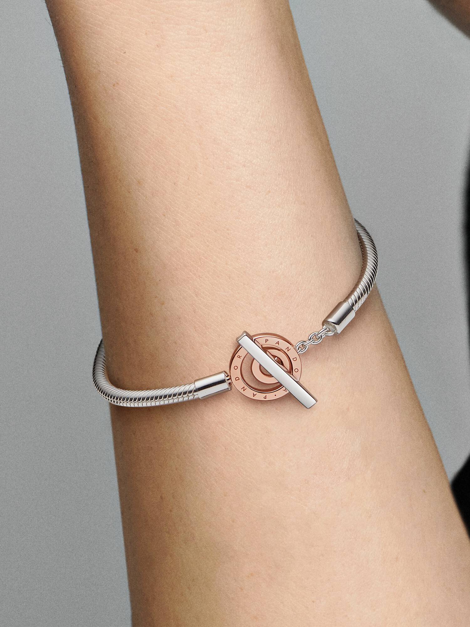 Srebrno-złota bransoletka typu wężykowego z logo Pandora Signature z zapięciem T